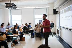Photo of Program Coordinator Shadiq Williams (right) speaks to CUNY students at a NYC Men Teach event.